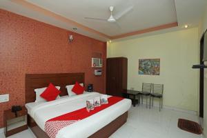 1 dormitorio con 1 cama grande y paredes rojas en Flagship Hotel Neel Ganga, en Haridwar