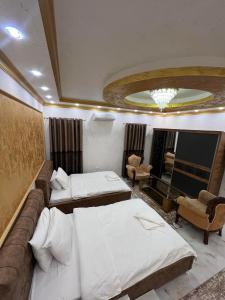 a hotel room with two beds and a couch at Hotel Premium in Pristina