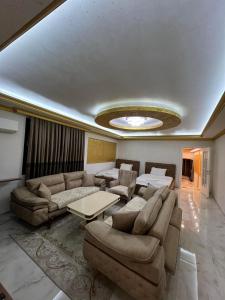 Hotel Premium في بريشتيني: غرفة معيشة مع أريكة وطاولة