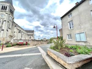 an empty street in front of a building with a clock tower at La baillargeoise - Superbe maison à 7 min du parc in Saint-Georges-lès-Baillargeaux