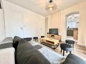 a living room with a couch and a tv at La baillargeoise - Superbe maison à 7 min du parc in Saint-Georges-lès-Baillargeaux