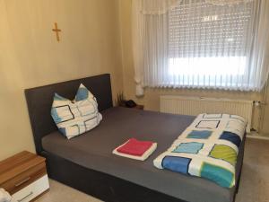 Un dormitorio con una cama con almohadas y una cruz en Schönes Ferienhaus in Filsen, en Filsen