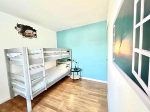 a bedroom with bunk beds and a blue wall at La baillargeoise - Superbe maison à 7 min du parc in Saint-Georges-lès-Baillargeaux
