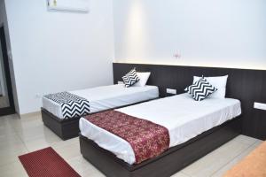 two beds in a hotel room withskirts at Hotel Shivlok International By BookingCare in Satna