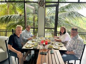 a group of people sitting at a table eating food at Amanzi Residence in Kandy