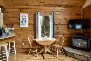 a dining room with a table and chairs and a fireplace at Cozy Cabin Retreat: Tiny Trotter in Bryson City