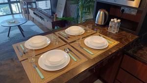 a table with plates and glasses on top of it at Anggun Residence KLCC (LuxLofts) in Kuala Lumpur