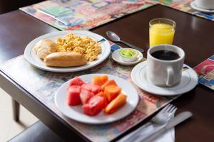 einen Tisch mit zwei Tellern Frühstückslebensmittel und einer Tasse Kaffee in der Unterkunft Hotel Plaza Las Américas Cali in Cali