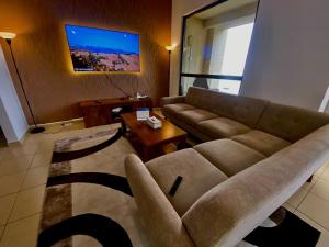 sala de estar con sofá y TV en Sea View Beach Hostel - Walk to Beach - Metro Station - Pool, en Dubái