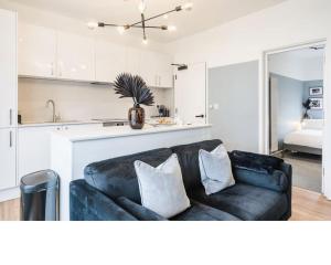 a living room with a black couch and a kitchen at Newport's heart: Steps from shops & local charm! in Newport