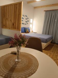 Una habitación con una mesa con un jarrón de flores. en PERIVOLI 1-CHORA(5min away from the center by car), en Agkidia