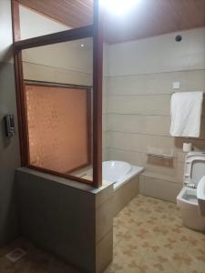 a bathroom with a bath tub and a toilet at Deep Sea Resort in Kitale