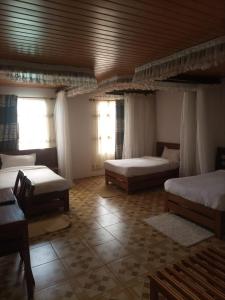 una camera con 3 letti e un soffitto in legno di Deep Sea Resort a Kitale