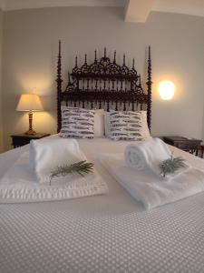 a bed with two white towels on top of it at Quinta de Marzovelos in Viseu