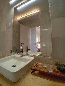 een badkamer met een grote witte wastafel en een spiegel bij Quinta de Marzovelos in Viseu