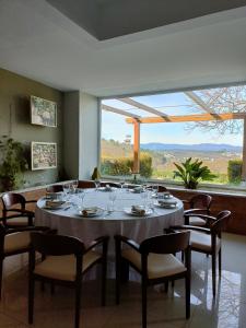 uma sala de jantar com mesa e cadeiras e uma grande janela em Quinta de Marzovelos em Viseu