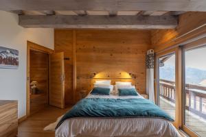 1 dormitorio con 1 cama con pared de madera en Chalet Hygge avec piscine en Saint-Gervais-les-Bains