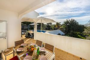 a patio with a table and chairs on a balcony at Casa Neel in Boliqueime