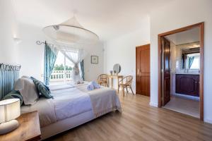 a bedroom with a large bed and a table at Casa Neel in Boliqueime +24 photos
