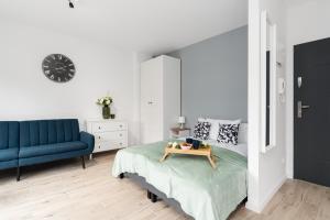 波茲南的住宿－Studio Apartment Krośnieńska with Balcony by Renters，一间卧室配有一张床和一张蓝色的沙发