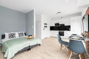 波茲南的住宿－Studio Apartment Krośnieńska with Balcony by Renters，白色卧室配有床和桌椅