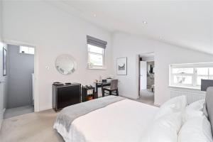 a white bedroom with a bed and a desk at £4 Million Covent Garden Apartment in London