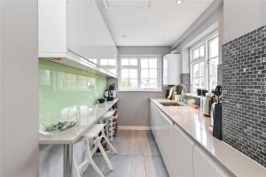 a kitchen with white cabinets and a counter top at £4 Million Covent Garden Apartment in London
