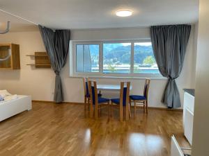 jadalnia ze stołem i krzesłami oraz oknem w obiekcie Appartement Emat 13 w mieście Telfs