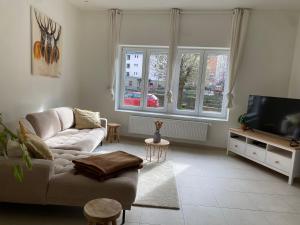 a living room with a couch and a tv at L'authentique in La-Roche-en-Ardenne