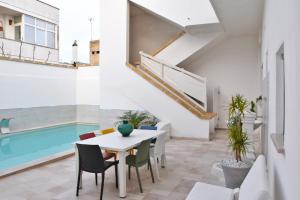 a dining room with a table and chairs and a swimming pool at Appartamento Arlena by Salento Affitti in Alliste