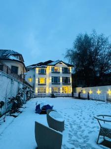 un patio cubierto de nieve con un edificio en el fondo en De Elaaf The Luxury Stay, en Srinagar