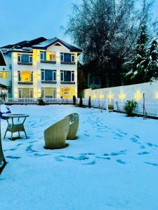 a snow covered yard in front of a building at De Elaaf The Luxury Stay in Srinagar
