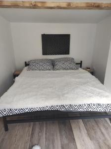 a bed with a black and white comforter in a bedroom at Klid in Budyně nad Ohří