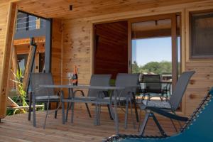 a patio with a table and chairs on a deck at River house Bonaca - Ada Bojana in Ulcinj