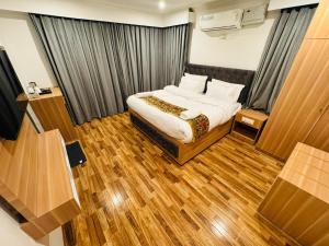 a bedroom with a bed and wooden floors at De Elaaf The Luxury Stay in Srinagar