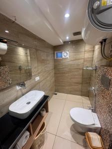 La salle de bains est pourvue d'un lavabo et de toilettes. dans l'établissement De Elaaf The Luxury Stay, à Srinagar