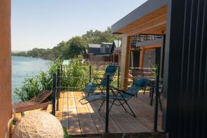 a porch with chairs and a deck with a view of the water at River house Bonaca - Ada Bojana in Ulcinj