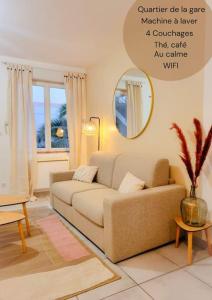 a living room with a couch and a mirror at Chez Augustin T2 cosy in Montauban