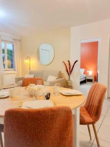 a dining room table with chairs and a living room at Chez Augustin T2 cosy in Montauban
