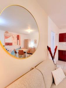 ein Wohnzimmer mit einem Sofa und einem Spiegel in der Unterkunft Chez Augustin T2 cosy in Montauban