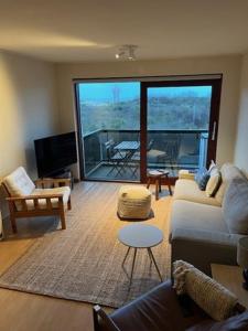 un salon avec un canapé et une table dans l'établissement CREVETTE Gezellig appartement met zonnige terrassen en zeezicht - Toplocatie!, à Coxyde 21 autres photos