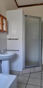 a bathroom with a glass shower and a sink at Panorama Chalets & Rest Camp in Graskop