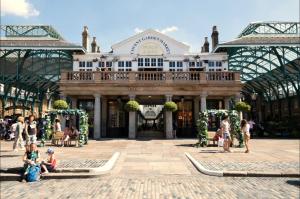 un grande edificio con persone sedute di fronte ad esso di £4 Million Covent Garden Apartment a Londra