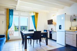 een keuken en eetkamer met een tafel en stoelen bij Le Goyave – Bel appartement cosy en résidence in Le Gosier
