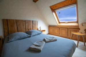 a bedroom with a bed with two towels on it at Le Gîte des Près. (accepte les animaux) in Lapoutroie