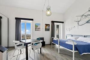1 dormitorio con 1 cama, mesa y sillas en Ostello Bello Genova, en Génova