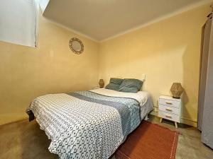 1 dormitorio con 1 cama y reloj en la pared en T2 lumineux hypercentre, en Millau