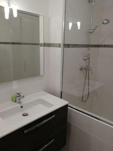 een witte badkamer met een douche en een wastafel bij T3- vue mer - Plage 50 m in Martigues
