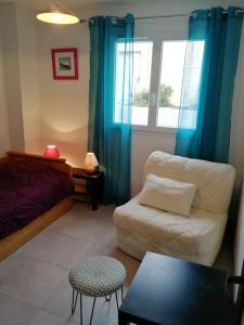 sala de estar con sofá y silla en T3- vue mer - Plage 50 m, en Martigues