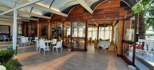 um restaurante com mesas brancas e cadeiras brancas em APPARTAMENTO AL MARE CON PISCINA em Rodi Garganico